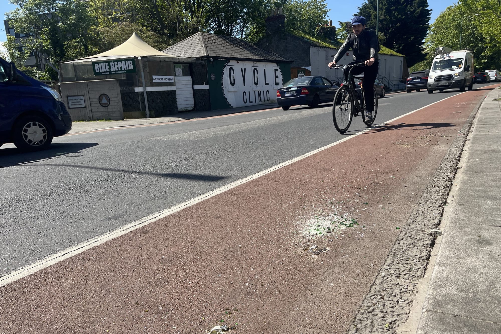 A cyclist avoiding glass in a cycle lane. 