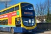 A yellow Dublin Bus fills most of the image, its neon lettering on the front says: "We are hiring!"