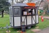 A trailer with signs saying "Chilli Pepper" and "Peruvian Food". A man and woman are visible through the hatch.