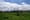 File photo of green grass and a blue sky with white clouds and a long industrial building at the old Chivers factory site in