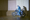 Stephen Skrynka on a motorcycle next to his wooden Wall of Death, casting a shadow on it.